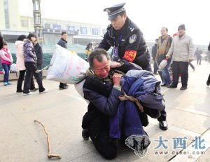 1月8日，山西太原火車站，一位沒有身份證的老農(nóng)滯留車站廣場，一民警幫他辦理臨時身份證、購票，老農(nóng)才順利上車。圖為老農(nóng)跪謝民警，民警幫老人扛好行李。 