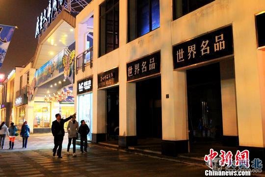 散步路過常熟市民在指點已關(guān)門的“世界名品店”。　李克祥　攝