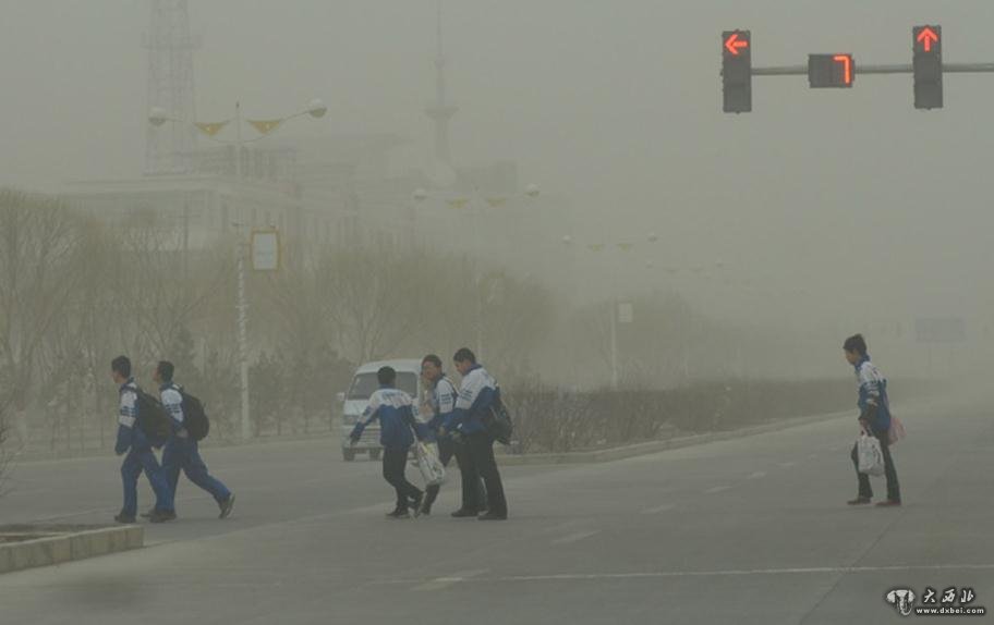 圖為玉門市民在沙塵暴天氣艱難出行。