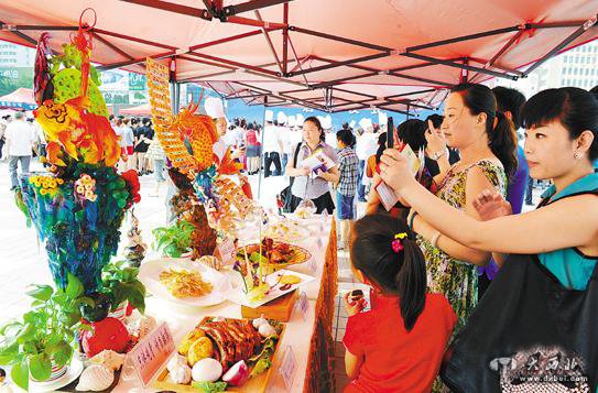 6月29日，在蘭州東方紅廣場上展出的美食作品吸引市民駐足。當日，甘肅“大眾餐飲消費季”活動在蘭州啟動。本報記者盛學卿